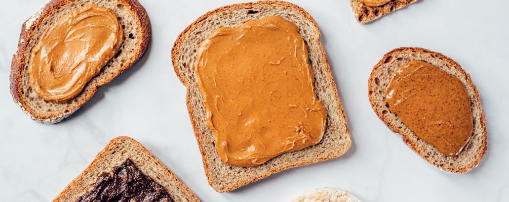 Spreading homemade nut butter on whole-grain toast.